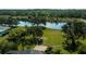 Expansive backyard featuring a tranquil pond view and lush, green lawn with mature trees at 2002 Palm View Rd, Sarasota, FL 34240
