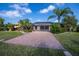 Large backyard with a brick paved area, landscaping, and screened-in pool enclosure at 2002 Palm View Rd, Sarasota, FL 34240