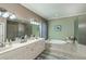 Bright bathroom with double sinks, soaking tub, a walk-in shower, and tile flooring at 2002 Palm View Rd, Sarasota, FL 34240