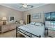 This cozy bedroom includes a ceiling fan, plush carpet, dresser, and an open window view to a pool at 2002 Palm View Rd, Sarasota, FL 34240