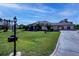 A single-story home with a well-manicured lawn, mature trees, and a long driveway under a blue sky at 2002 Palm View Rd, Sarasota, FL 34240