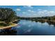 Aerial shot of a serene pond reflecting the sky, surrounded by trees at 2002 Palm View Rd, Sarasota, FL 34240