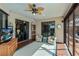 Relaxing sunroom features glass door and windows, comfortable seating area, and a tropical-style ceiling fan at 2002 Palm View Rd, Sarasota, FL 34240