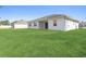 Expansive backyard featuring lush green grass and a covered patio area at 2157 Snug St, North Port, FL 34286