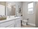 Bright bathroom features a white vanity, neutral walls, and a framed mirror at 2157 Snug St, North Port, FL 34286