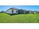 Expansive backyard showcasing lush, green lawn and serene views of the home's exterior at 217 Potenza Loop, North Venice, FL 34275