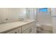 Bathroom with white vanity, marble countertops, large mirror, and tub with shower at 217 Potenza Loop, North Venice, FL 34275