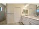 Bathroom with double sink vanity, a large mirror, and a tiled shower with glass door at 217 Potenza Loop, North Venice, FL 34275