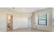 An open bedroom with connecting bathroom features tile floors and a light-filled window at 217 Potenza Loop, North Venice, FL 34275
