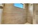 Walk-in shower features neutral tiling, a showerhead, and a window for natural light at 217 Potenza Loop, North Venice, FL 34275