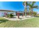 Spacious backyard with a screened lanai, tropical landscaping, and a well-maintained lawn at 221 Fairway Rd, Rotonda West, FL 33947
