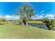Expansive backyard with mature landscaping and a serene canal providing a picturesque backdrop at 221 Fairway Rd, Rotonda West, FL 33947