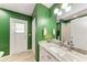 Bathroom featuring green walls, white cabinets and a white marble countertop at 221 Fairway Rd, Rotonda West, FL 33947