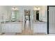 Bright bathroom with dual vanities, granite countertops, and a view to the outdoor living area at 221 Fairway Rd, Rotonda West, FL 33947