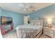 A bright bedroom featuring blue walls, wood-look flooring and a ceiling fan at 221 Fairway Rd, Rotonda West, FL 33947