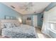 A bright bedroom featuring blue walls, wood-look flooring and a ceiling fan at 221 Fairway Rd, Rotonda West, FL 33947