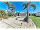 Inviting home with an extended driveway flanked by lush landscaping and towering palm trees at 221 Fairway Rd, Rotonda West, FL 33947