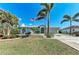 Charming single-story home featuring a well-maintained lawn, palm trees, and a delightful American flag at 221 Fairway Rd, Rotonda West, FL 33947