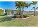 Beautiful single-story home showcasing a lush front yard with manicured landscaping and elegant palm trees at 221 Fairway Rd, Rotonda West, FL 33947