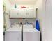 Functional laundry room with washer, dryer, storage cabinets, and cleaning supplies for convenience at 221 Fairway Rd, Rotonda West, FL 33947