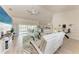Bright living room showcasing modern white furniture, a large TV, and sliding glass doors leading to the pool area at 221 Fairway Rd, Rotonda West, FL 33947