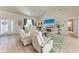 Spacious living room with a ceiling fan, modern white furniture, and a large TV for entertainment at 221 Fairway Rd, Rotonda West, FL 33947