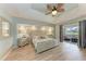 Serene main bedroom with tray ceilings, a decorative ceiling fan, and an en-suite bathroom with lanai access at 221 Fairway Rd, Rotonda West, FL 33947