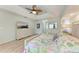 Serene main bedroom with tray ceilings, a decorative ceiling fan, and an en-suite bathroom at 221 Fairway Rd, Rotonda West, FL 33947
