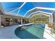 Relaxing screened-in pool area with comfortable seating and lush tropical landscaping at 221 Fairway Rd, Rotonda West, FL 33947