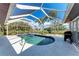 Screened in pool area with a clear blue pool, and tropical foliage around the perimeter at 221 Fairway Rd, Rotonda West, FL 33947