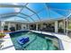 Inviting screened-in pool area with clear blue water, patio furniture, and well-maintained landscaping at 221 Fairway Rd, Rotonda West, FL 33947