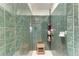 Green tiled shower featuring a wooden shower seat and corner caddy at 221 Fairway Rd, Rotonda West, FL 33947