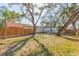 Large backyard with mature trees, lush green lawn, and a white home with a black roof at 2300 23Rd S St, St Petersburg, FL 33712