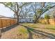 Picturesque backyard featuring mature trees, a manicured lawn, and a charming white cottage-style home at 2300 23Rd S St, St Petersburg, FL 33712