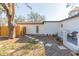 Backyard with stepping stones leading to a white door and wooden fence, offering a private outdoor space at 2300 23Rd S St, St Petersburg, FL 33712