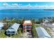 Aerial view of a pink home with a tile roof and a waterfront view with multiple docks at 2306 Canasta Dr, Bradenton Beach, FL 34217
