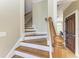 Elegant staircase featuring hardwood steps and white risers leading to the next level of the home at 2306 Canasta Dr, Bradenton Beach, FL 34217