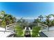 Enjoy the view from the balcony with two green chairs overlooking the water and palm trees at 2308 Canasta Dr, Bradenton Beach, FL 34217