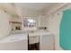 Bright laundry room with washer, dryer, utility sink, and ample storage space at 2308 Canasta Dr, Bradenton Beach, FL 34217