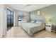 Calm bedroom with patio access, soft green accent wall, and bright natural lighting at 2431 Bayshore Gardens Pkwy # 19, Bradenton, FL 34207