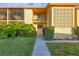 Close up of the condo's exterior entrance with a well-manicured lawn, welcoming walkway, and inviting architecture at 2431 Bayshore Gardens Pkwy # 19, Bradenton, FL 34207