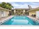 Community pool and surrounding deck with chairs and lush landscaping at 2431 Bayshore Gardens Pkwy # 19, Bradenton, FL 34207