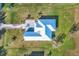 Aerial view of a home featuring a silver metal roof, lush lawn, and decorative driveway at 28960 Gin Ln, Punta Gorda, FL 33982