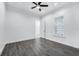 Minimalist bedroom features wood-look floors, ceiling fan, and natural light from a window at 28960 Gin Ln, Punta Gorda, FL 33982