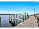 A picturesque private dock on the water featuring a boat lift, wood railings, and calm waters at 28960 Gin Ln, Punta Gorda, FL 33982