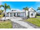 Stunning single-story home boasts lush landscaping, a brick driveway, and a stylish metal roof at 28960 Gin Ln, Punta Gorda, FL 33982
