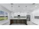 Gourmet kitchen with a large island, pendant lights, white cabinets, and modern appliances at 28960 Gin Ln, Punta Gorda, FL 33982