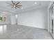 Spacious living room with light gray tiled floors, plenty of natural light, and a modern ceiling fan at 28960 Gin Ln, Punta Gorda, FL 33982