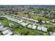 Quiet neighborhood setting featuring mature trees, lush green grass, and golf course at 3278 Village Green Dr # 1024, Sarasota, FL 34239
