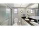 Well-lit bathroom with glass shower, black countertops, white cabinets, and a comfortable toilet at 3278 Village Green Dr # 1024, Sarasota, FL 34239